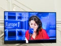 Big TV on the white wall in the hall in a modern style. On TV the radio show from EUROPE 1 Royalty Free Stock Photo