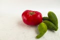 Big ugly tomato and ugly cucumbers on a white background