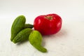 Big ugly tomato and ugly cucumbers on a white background