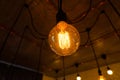 Big vintage incandescent light bulbs hanging in modern kitchen. Inefficient filament light bulbs waste electricity. Dimmable, warm