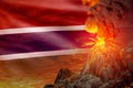 conical volcano eruption at night with explosion on Gambia flag background, problems of eruption and volcanic ash conceptual 3D