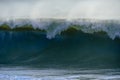 A big wave crashes on the beach