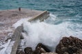 Big wave splash on pier. Big sea wave on a windy day. Waves crash against concrete breakwater at port entrance. Giant waves Royalty Free Stock Photo