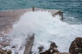 Big wave splash on pier. Big sea wave on a windy day. Waves crash against concrete breakwater at port entrance. Giant waves Royalty Free Stock Photo