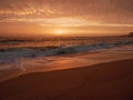 Big waves break on beach at sunset in Portugal with beautiful sky Royalty Free Stock Photo