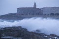 Big waves breaking on the promenade of La CoruÃÂ±a with the buildings of the city