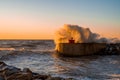 Big waves crashing against the coast at the tip of the pier near Pisa, Italy