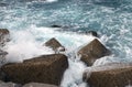 Big waves in the sea at the stone block jetty. Sea pier with breakwater stone cubes close-up view