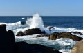 Big waves splashing against the rocks and fishing boat. Blue sea with white foam, sunny day. Galicia, Spain. Royalty Free Stock Photo