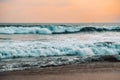 Big waves during a sunset in Hikkaduwa, Sri Lanka. Rough sea with beautiful pale sun going down in the background. Stormy weather Royalty Free Stock Photo