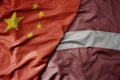 big waving national colorful flag of china and national flag of latvia