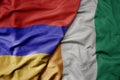 big waving national colorful flag of cote divoire and national flag of armenia