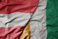 big waving national colorful flag of cote divoire and national flag of austria