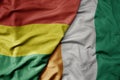 big waving national colorful flag of cote divoire and national flag of bolivia