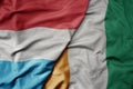 big waving national colorful flag of cote divoire and national flag of luxembourg