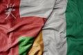 big waving national colorful flag of cote divoire and national flag of oman