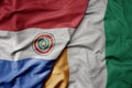 big waving national colorful flag of cote divoire and national flag of paraguay