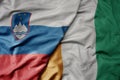 big waving national colorful flag of cote divoire and national flag of slovenia