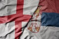 big waving national colorful flag of england and national flag of serbia Royalty Free Stock Photo