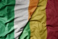 big waving national colorful flag of ireland and national flag of mali