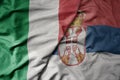 big waving national colorful flag of italy and national flag of serbia