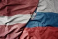 big waving national colorful flag of latvia and national flag of slovenia