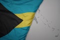 big waving national colorful flag and map of bahamas on the gray background