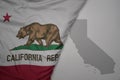 big waving national colorful flag and map of california state on the gray background Royalty Free Stock Photo