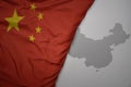 big waving national colorful flag and map of china on the gray background Royalty Free Stock Photo