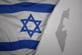 big waving national colorful flag and map of israel on the gray background