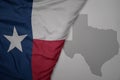 big waving national colorful flag and map of texas state on the gray background Royalty Free Stock Photo