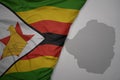 big waving national colorful flag and map of zimbabwe on the gray background