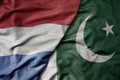 big waving national colorful flag of netherlands and national flag of pakistan
