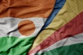 big waving national colorful flag of niger and national flag of seychelles Royalty Free Stock Photo