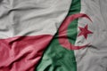 big waving national colorful flag of poland and national flag of algeria