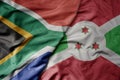 big waving national colorful flag of south africa and national flag of burundi Royalty Free Stock Photo