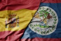 big waving national colorful flag of spain and national flag of belize