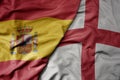 big waving national colorful flag of spain and national flag of england Royalty Free Stock Photo