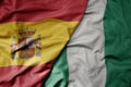 big waving national colorful flag of spain and national flag of nigeria Royalty Free Stock Photo