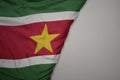 big waving national colorful flag of suriname on the gray background