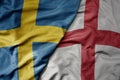 big waving national colorful flag of sweden and national flag of england Royalty Free Stock Photo