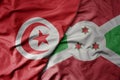 big waving national colorful flag of tunisia and national flag of burundi Royalty Free Stock Photo