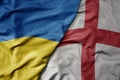 big waving national colorful flag of ukraine and national flag of england Royalty Free Stock Photo