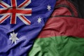 big waving realistic national colorful flag of australia and national flag of malawi