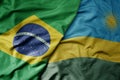 big waving realistic national colorful flag of brazil and national flag of rwanda