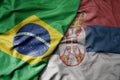 big waving realistic national colorful flag of brazil and national flag of serbia