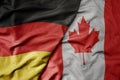 big waving realistic national colorful flag of germany and national flag of canada