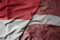 big waving realistic national colorful flag of indonesia and national flag of latvia