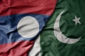 big waving realistic national colorful flag of laos and national flag of pakistan