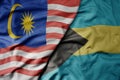 big waving realistic national colorful flag of malaysia and national flag of bahamas